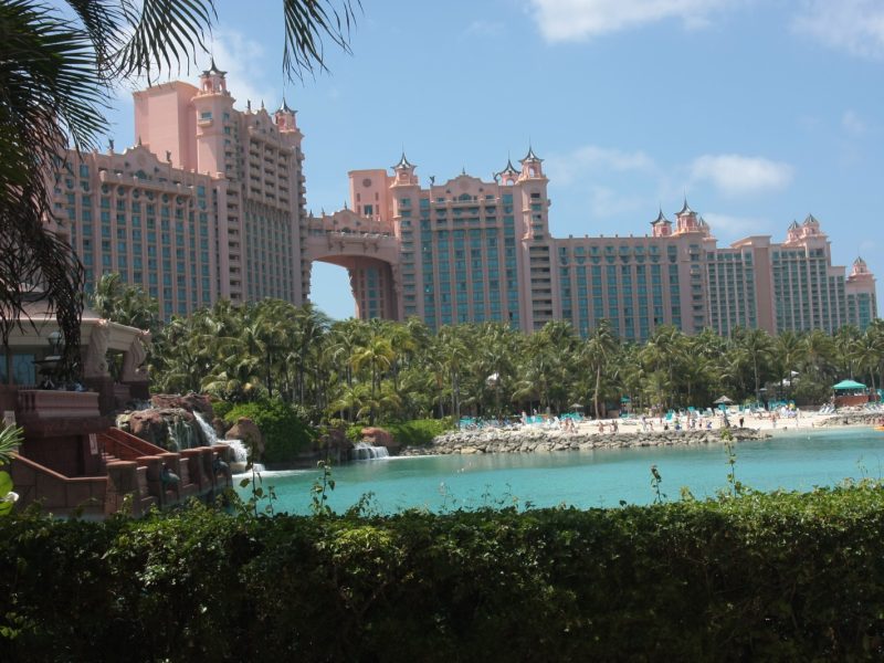 Atlantis Paradise Island resort's pink towers rising above palm trees and a turquoise lagoon pool
