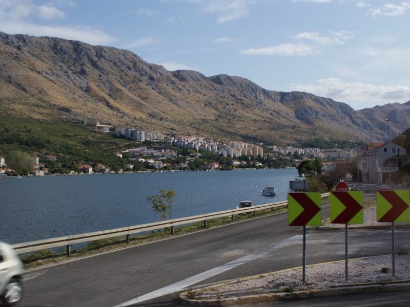 Coastal road along the Adriatic Sea with rugged mountains rising above the shoreline