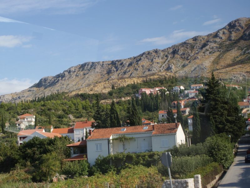 Small Dalmatian coastal town nestled below steep mountains along the sea