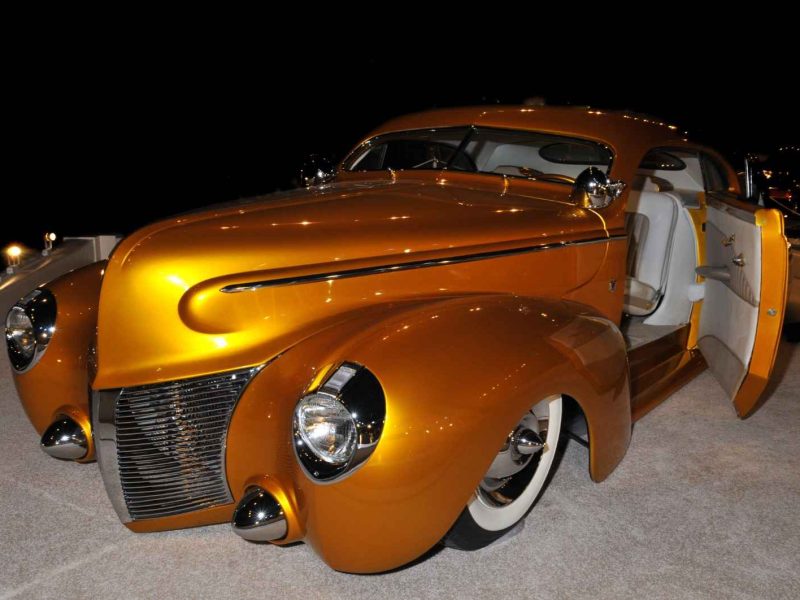 Gleaming gold classic car under lights