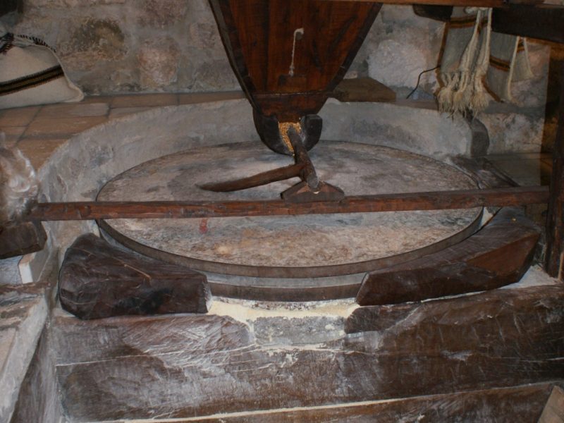 Close-up of a traditional stone grinding wheel inside an old watermill